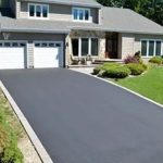 Newly paved asphalt driveway outside a modern house
