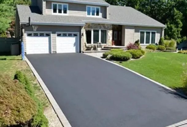 Newly paved asphalt driveway outside a modern house