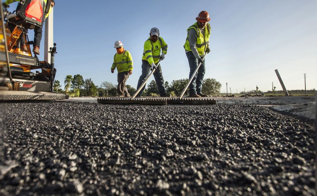 Asphalt maintenance team resurfacing residential driveway