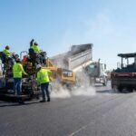 asphalt paving process with a professional crew laying and rolling fresh asphalt